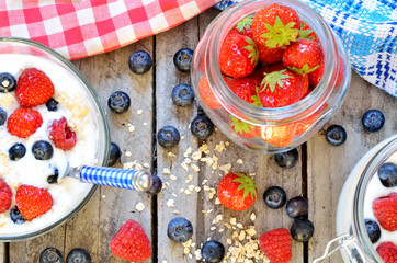 White yogurt in a bowl with oatmeal, blueberries, raspberries and strawberries