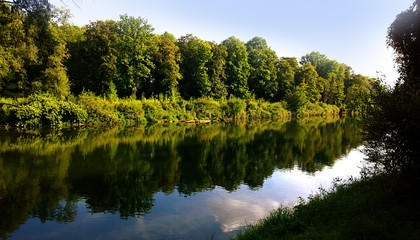 Fototapeta na wymiar Summer in Bavaria, Isar river with calm waters and sky reflection