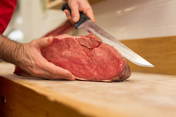 Close up of butcher cutting meat