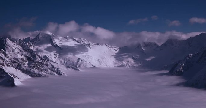 Zillertal, Tirol, Austria - peaks of snowy mountains and valley in the alps above the clouds at a sunny day - Timelapse without motion 