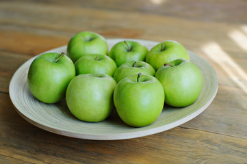Green apples on a wooden background.