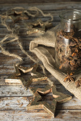 Garland of the Christmas star, a jar of anise on a wooden old table. Rustic style.