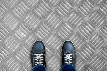 Black casual shoes standingon stainless steel floor