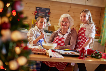 smiling kids preparing Xmas cookies with grandmother.
