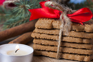 Gingerbreads with a ribbon on a wooden christmas table with a bl