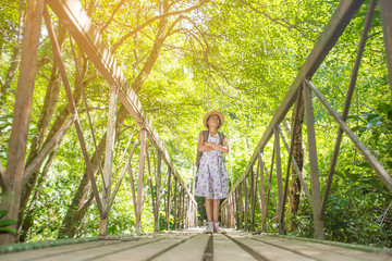 asian girl on the old bridge in the forest