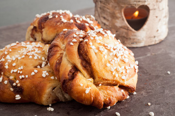 Traditional Swedish cinnamon buns served on a rustic plate. A very popular snack throughout Scandinavia known as Fika when taken with a cup of coffee.