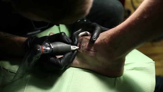 Master is drawind a tattoo