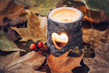Wood candle holder on fall leaves