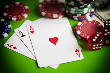 Playing cards, poker chips, and dices on green table