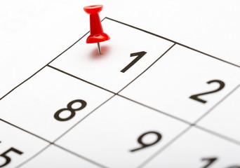 Pin on the date. The first day of the month is marked with a red thumbtack. Focus point on the red pin. - 126848584