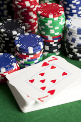 Playing cards and poker chips on green table