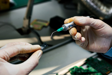 Microchip production factory. Technological process. Assembling the board. Chip. Professional. Technician. Computer expert. Manufacturing. Engineering.