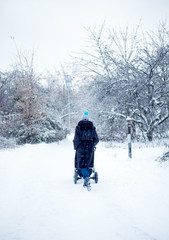 Fototapeta na wymiar Woman with pram walking in winter