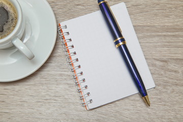 Desktop from above. Office space with an empty note book at coffee time looking for inspirational ideas