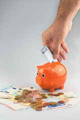 Feeding the piggy bank by hand.