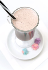 Cocoa with thick foam in a glass.