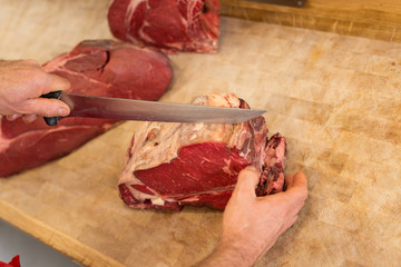 Butcher Cutting Meat At Counter high angle