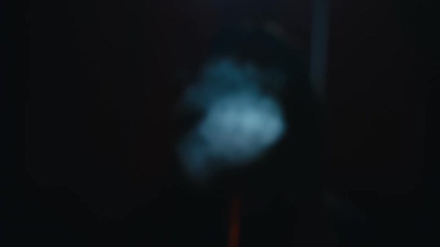 CU female exhaling smoke from a vapor into the camera. 4K UHD RAW edited footage