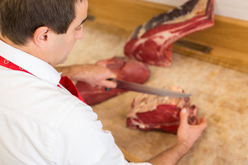 Butcher Cutting Meat At Counter high angle