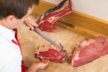 Butcher Cutting Meat At Counter high angle