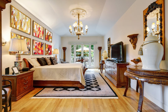 Luxury master bedroom interior with carved wooden furniture.