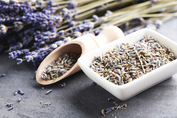 Lavender flowers in bowl and scoop on grey table