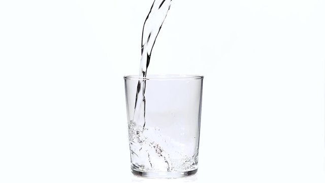 Water being poured into Glass against White Background, Slow Motion