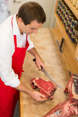 Butcher Cutting Meat At Counter high angle