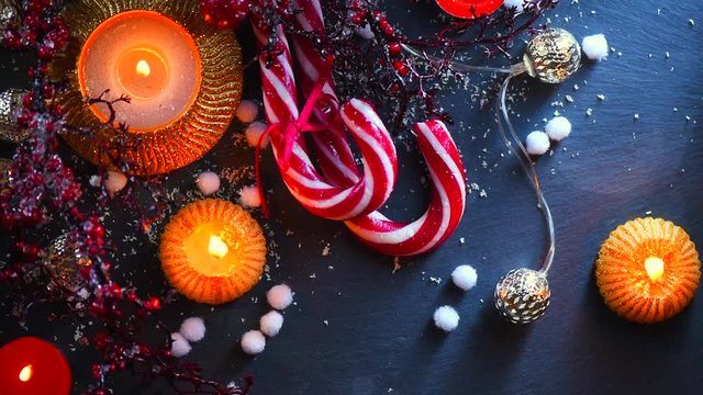 Christmas holiday background. Burning candles, candy cane and decorations. Full HD 1080p
