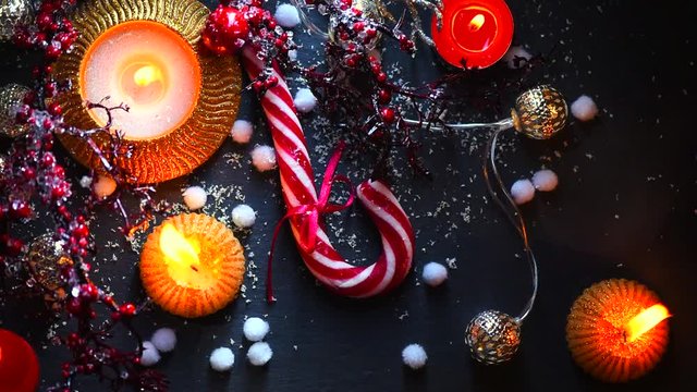 Christmas holiday background. Burning candles, candy cane and decorations. Full HD 1080p