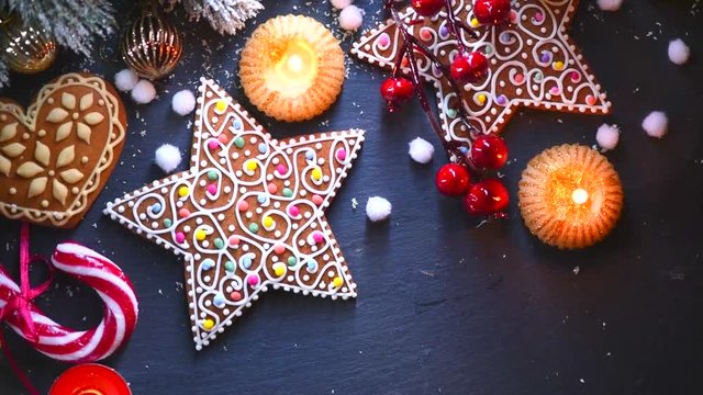 Christmas holiday background. Gingerbread cookies, decorations, burning candles on decorated table. Full HD 1080p