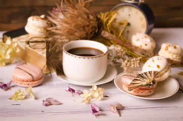Obraz na płótnie Canvas Cup of coffee with macaroons, dried flowers protea