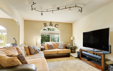 Cozy family room furnished with leather sofas with beige cushions.