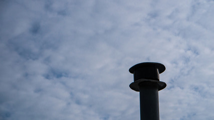 Smokestack with cloudy sky