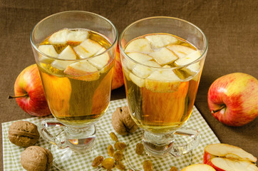 Hot apple cider with apples and slices in cups