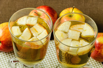 Hot apple cider with apples and slices in cups