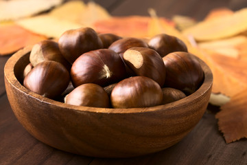 Chestnuts in wooden bowl, photographed with natural light (Selective Focus, Focus on the front of the chestnuts on the top)