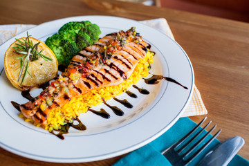 salmon steak with curry rice on a white plate
