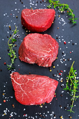 Fresh Raw Beef steak Mignon, with salt, peppercorns, thyme, garlic Ready to cook