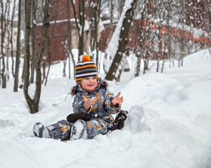 Fototapeta na wymiar Child playing with snow in winter