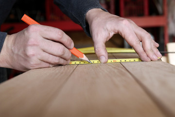 Construction Worker Using Tape Measure and pencil