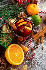 Hot Mulled wine with cinnamon sticks, orange, lime. christmas concept.