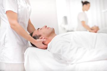 Obraz na płótnie Canvas Male client enjoying facial treatment at spa