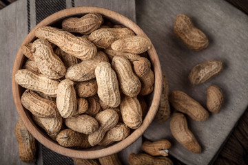 Dried peanuts in wooden bowl.