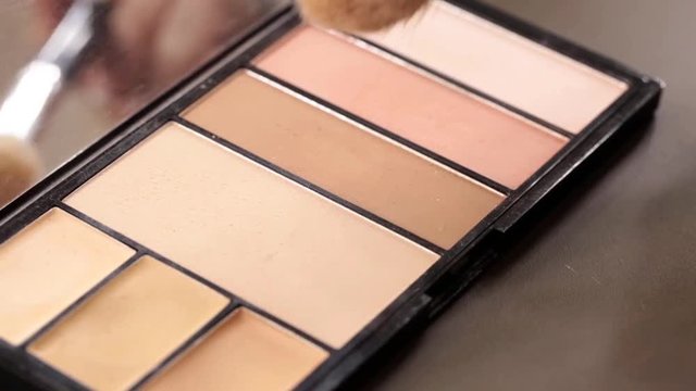 Close up of makeup brush moving over eye shadows