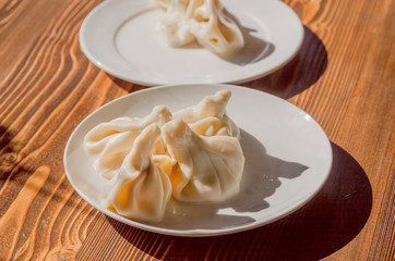 Kitchen with Khinkali dish on plate. Georgian dumpling with meat, or cheese, or mushrooms. Traditional Caucasian cuisine