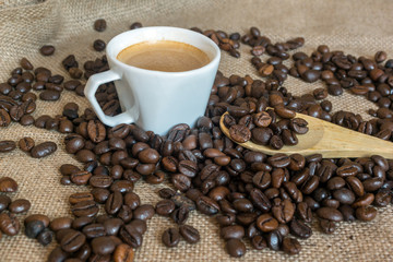 Cup and grain of coffee over textile background