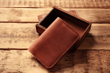 Stylish leather passport cover with box on wooden background