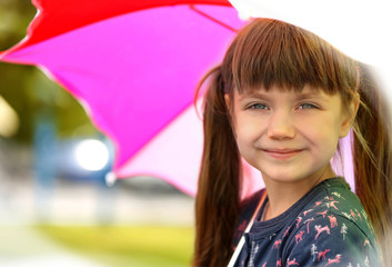 Portrait of cute girl with umbrella outdoors